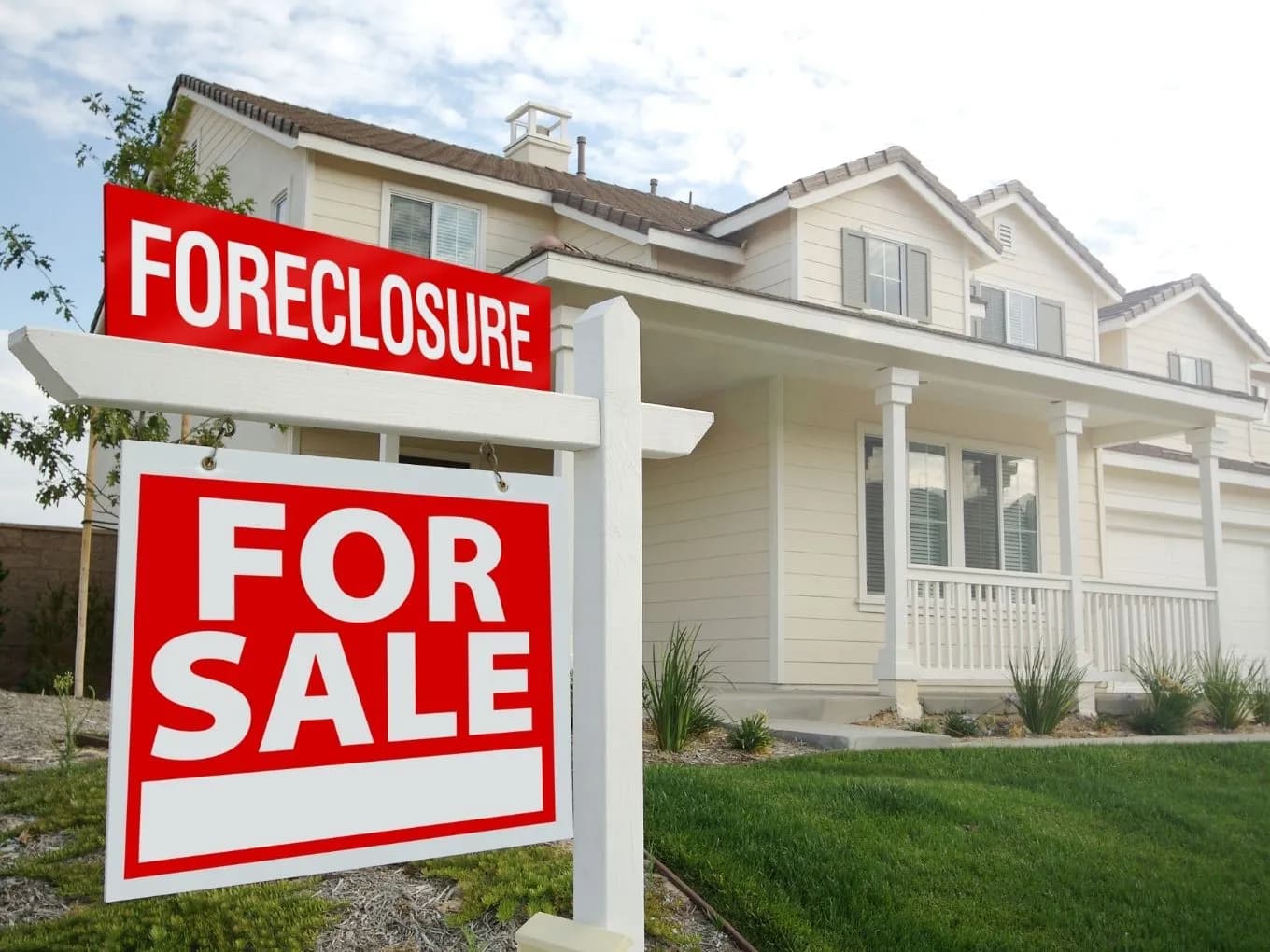 house with foreclosure and for sale sign in front of it 