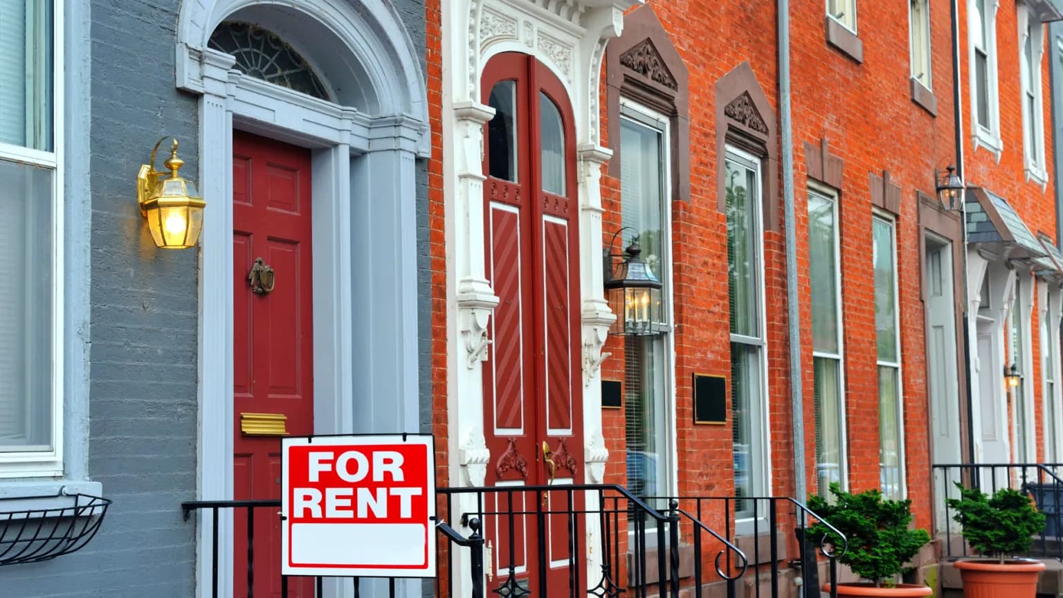 exterior image of rowhomes with for rent sign