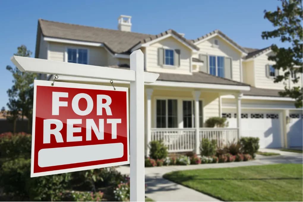 yellow house with for rent sign in front