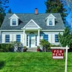 exterior image of white home with for rent sign