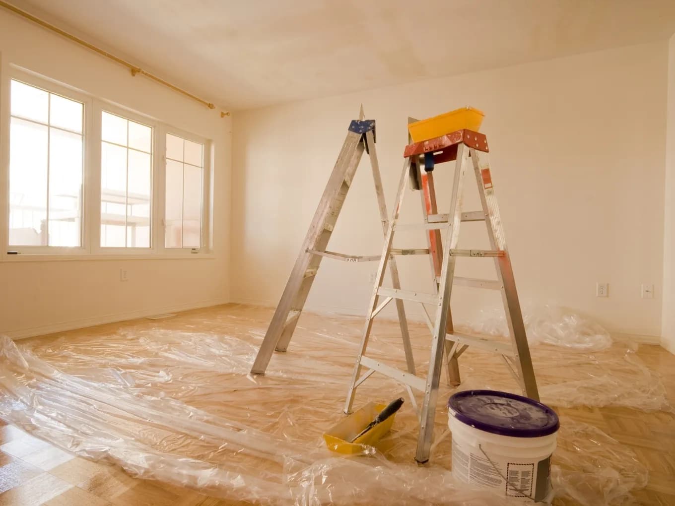 Two ladders in middle of empty room