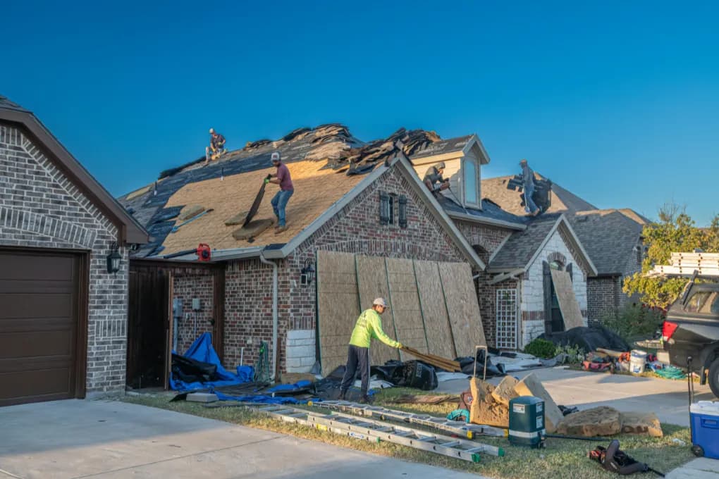 Workers fixing a roof on a home.