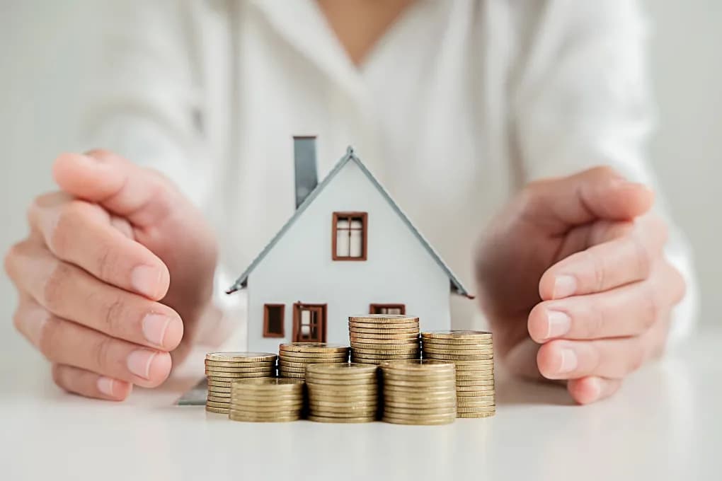 image of toy house placed between two hands
