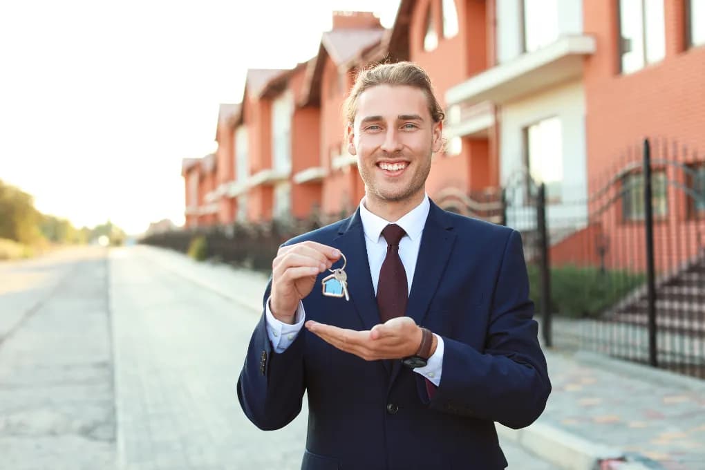 image of man in suit standing in front of houses with keys
